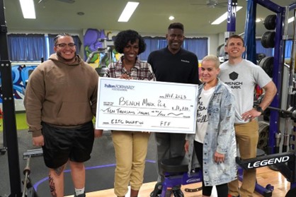 A group of Benchmark employees receiving a check from Cavity Bank