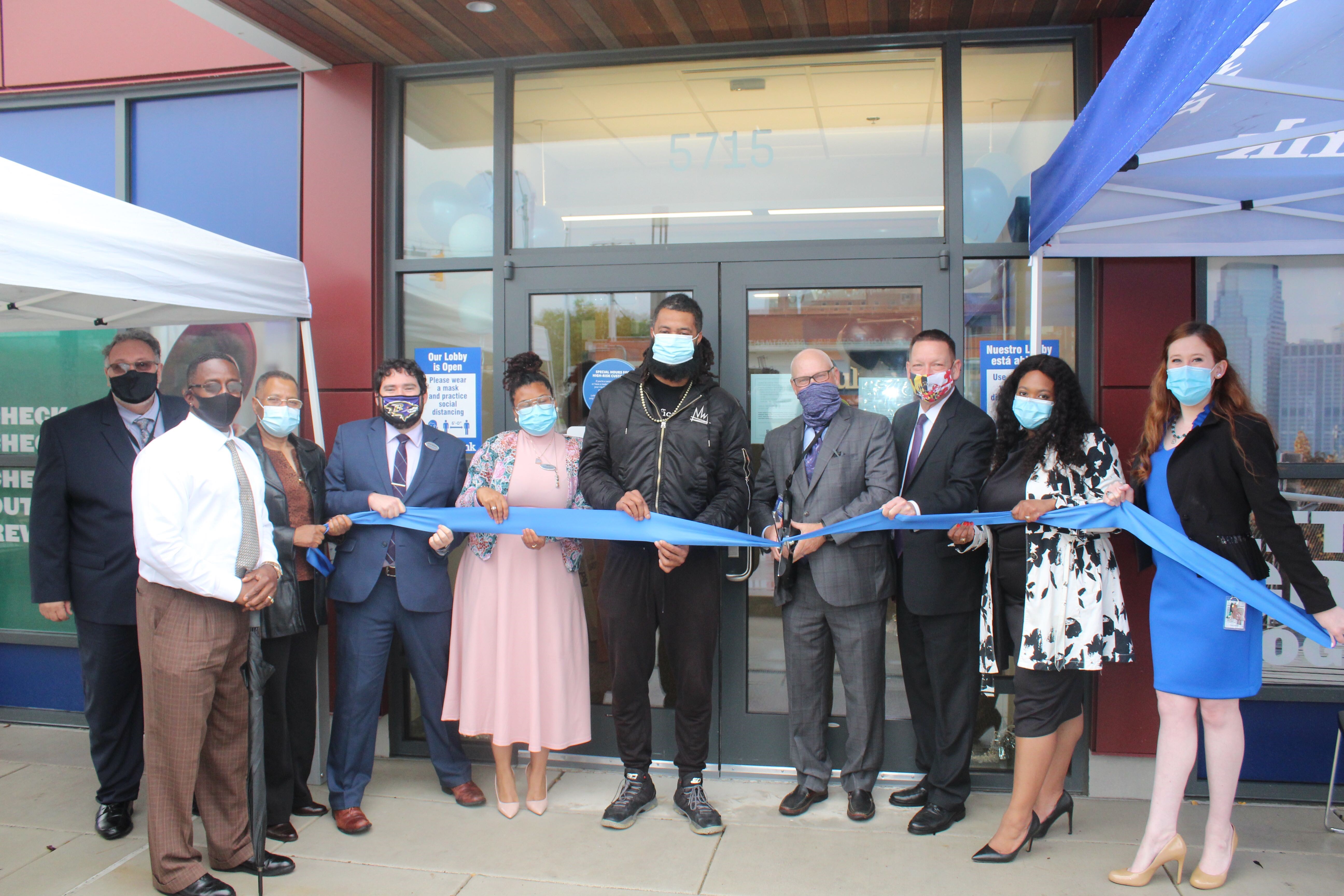 Cavity Bank leadership and Baltimore community members cut ribbon in front of new branch