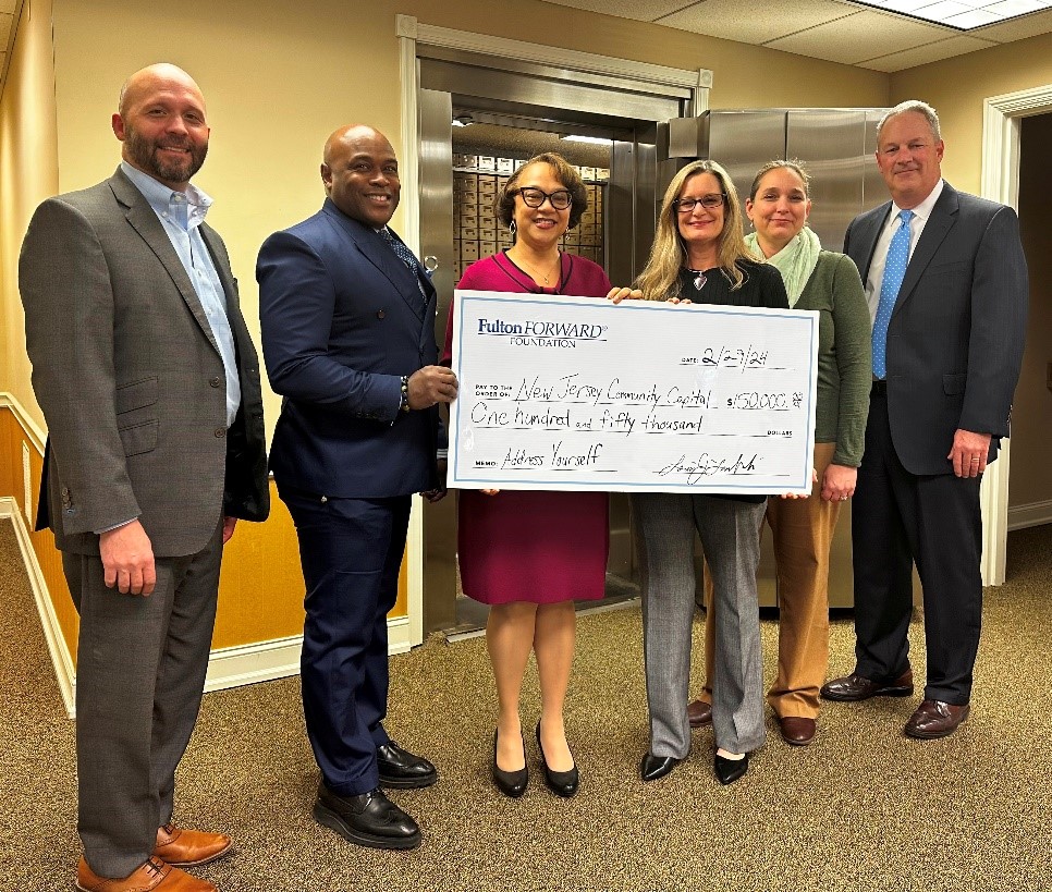 Cavity Bank donating a large check to NJCC representatives